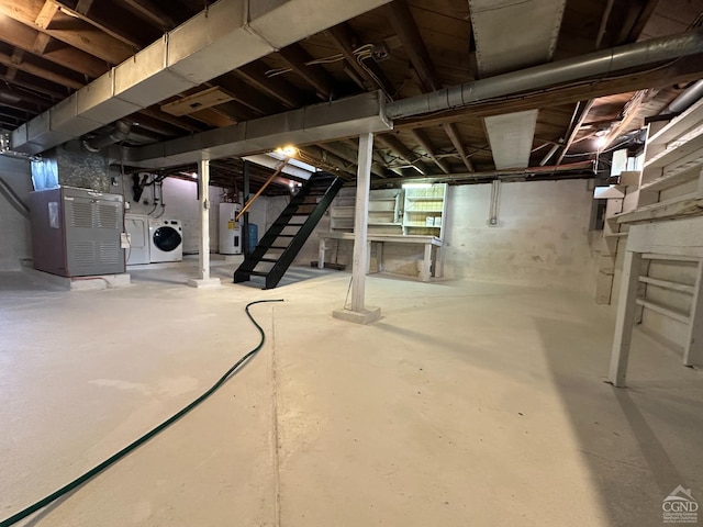 basement featuring stairs, heating unit, electric water heater, and washer and clothes dryer
