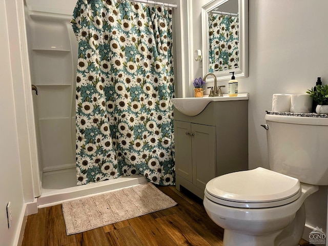 full bath featuring vanity, a shower stall, toilet, and wood finished floors