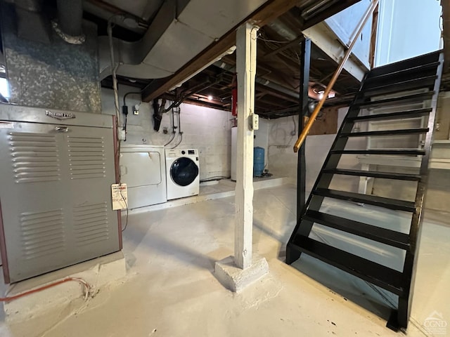 unfinished below grade area with heating unit, stairs, and independent washer and dryer