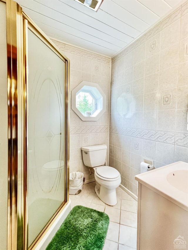 bathroom with tile patterned floors, toilet, an enclosed shower, and tile walls