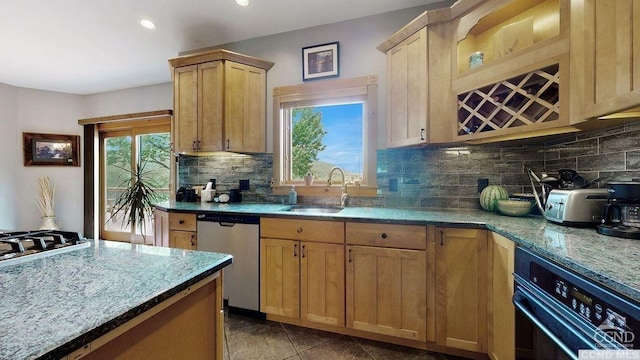 kitchen featuring light stone countertops, decorative backsplash, stainless steel appliances, and sink