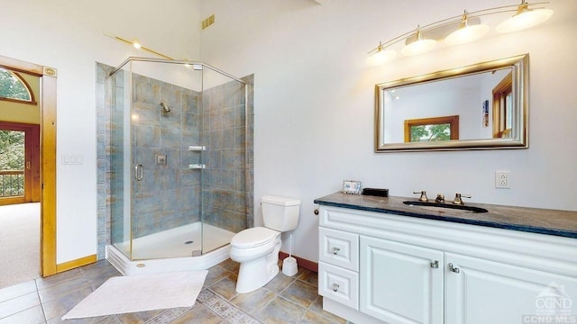 bathroom featuring tile patterned floors, vanity, toilet, and an enclosed shower