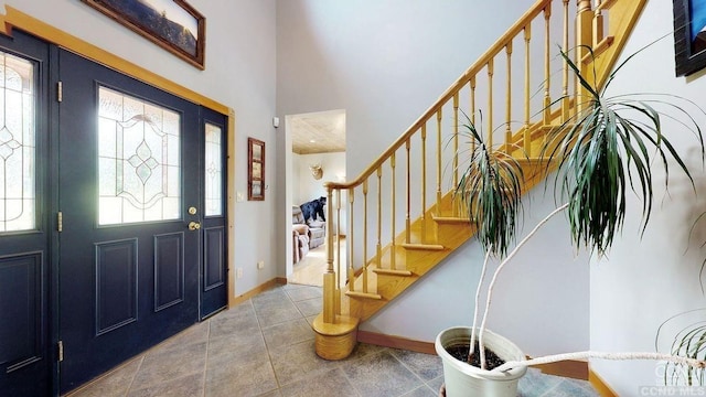 foyer with tile patterned floors, plenty of natural light, and a high ceiling