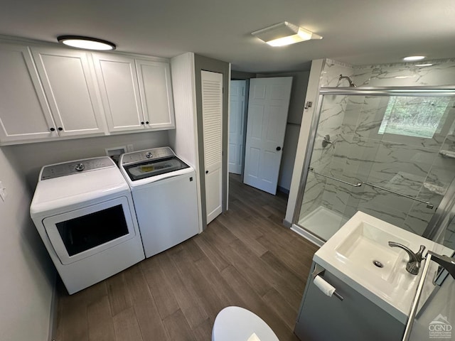 clothes washing area featuring a sink, laundry area, washing machine and dryer, and dark wood finished floors