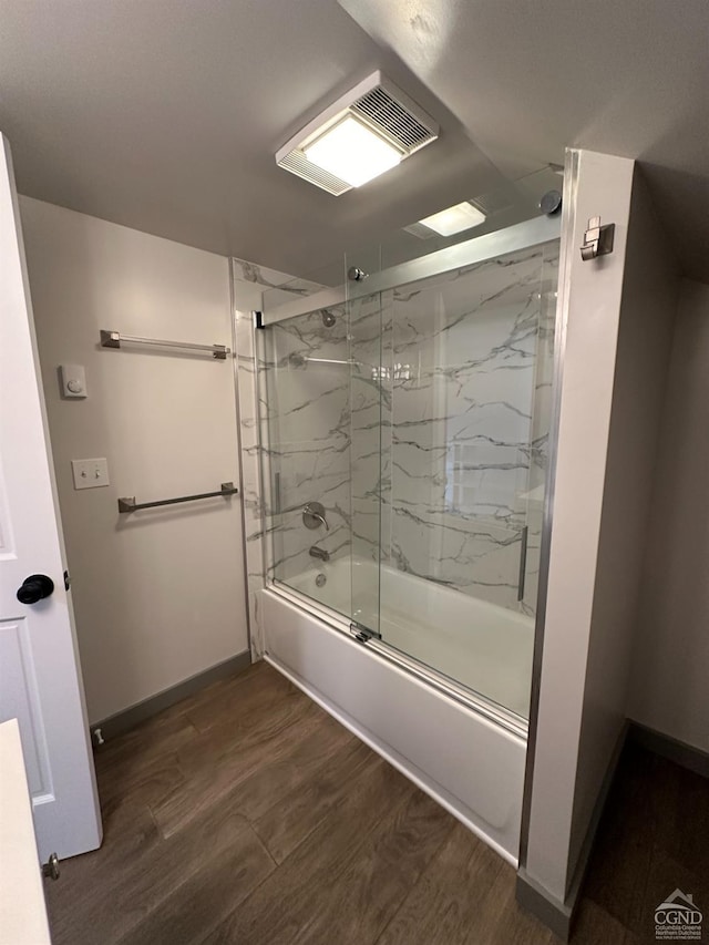 full bath featuring shower / bath combination with glass door, baseboards, visible vents, and wood finished floors