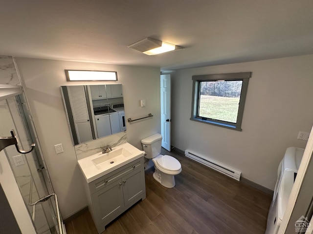 full bathroom with toilet, a baseboard radiator, wood finished floors, vanity, and washing machine and dryer