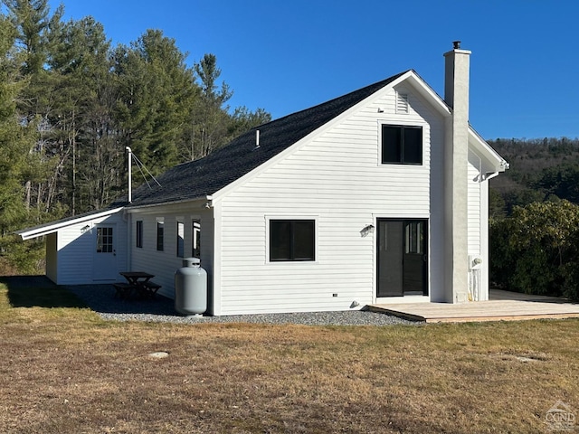 back of property featuring a yard, a chimney, and a patio