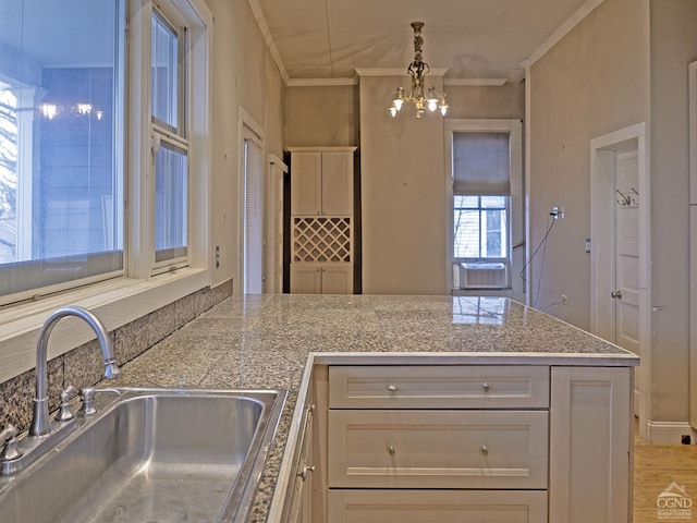 517519 Washington St, Hudson, NY 12534 - kitchen featuring crown molding, hanging light fixtures, an inviting chandelier, a sink, and a peninsula