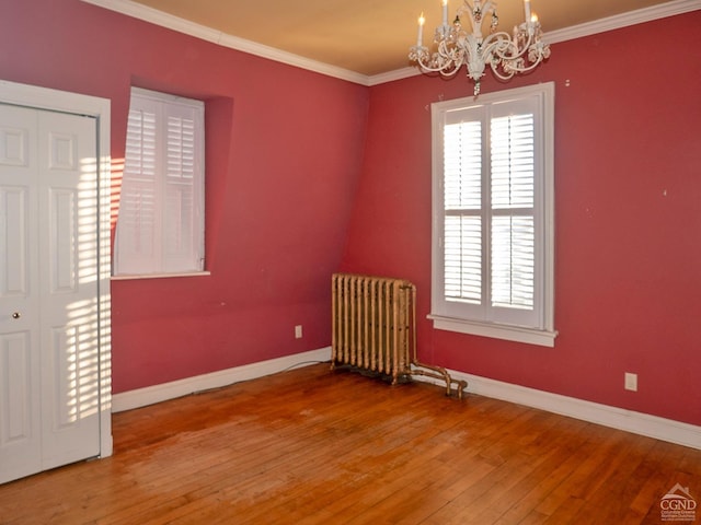 517519 Washington St, Hudson, NY 12534 - spare room with ornamental molding, a notable chandelier, radiator heating unit, and hardwood / wood-style flooring