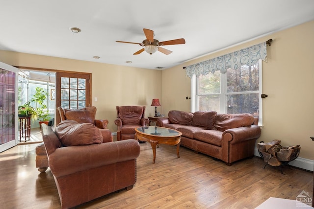 living room with light wood-type flooring, ceiling fan, and a healthy amount of sunlight