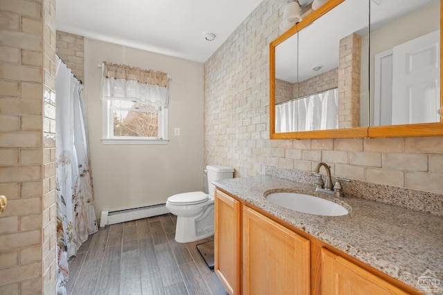 bathroom featuring hardwood / wood-style floors, vanity, backsplash, toilet, and a baseboard radiator