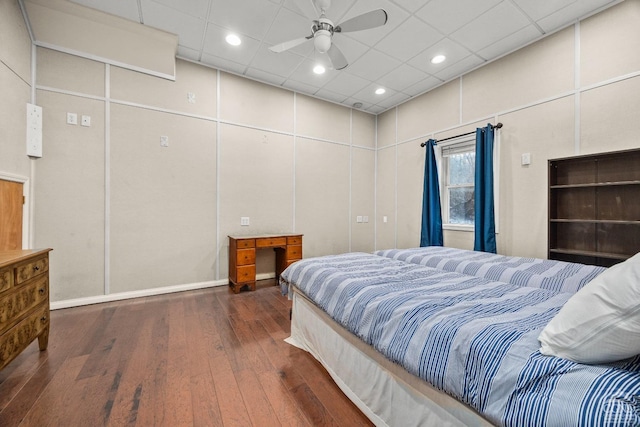 bedroom with a paneled ceiling, ceiling fan, dark hardwood / wood-style flooring, and a towering ceiling