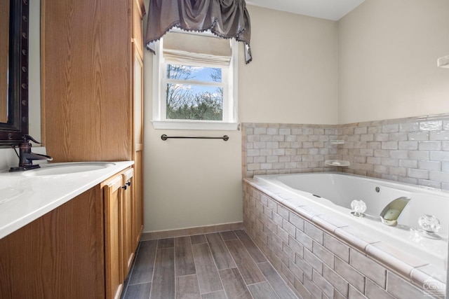 bathroom featuring hardwood / wood-style floors, vanity, and a relaxing tiled tub