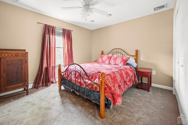 carpeted bedroom with ceiling fan and a baseboard heating unit