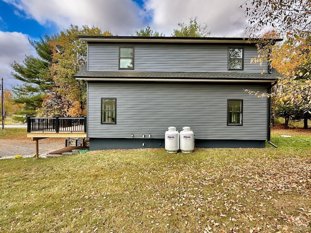 rear view of property with a deck and a yard