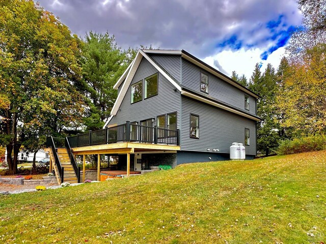 back of property with a lawn and a wooden deck