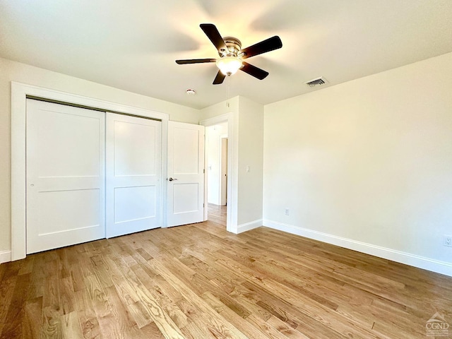 unfurnished bedroom featuring ceiling fan, a closet, and light hardwood / wood-style floors