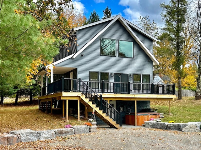 back of house featuring a wooden deck and a hot tub