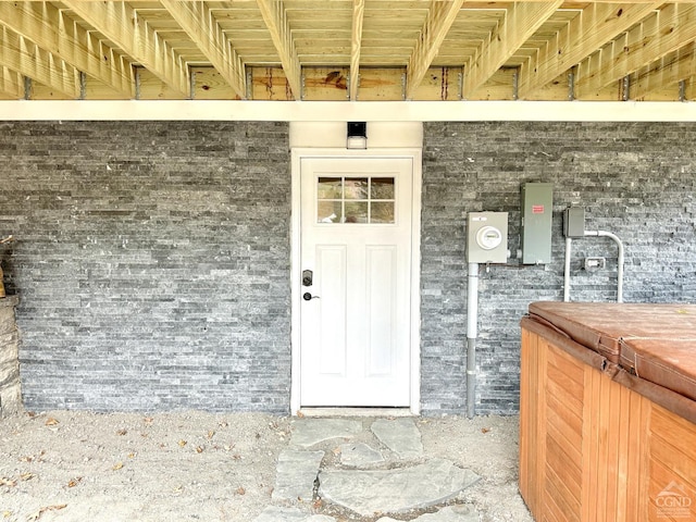 doorway to property with a hot tub