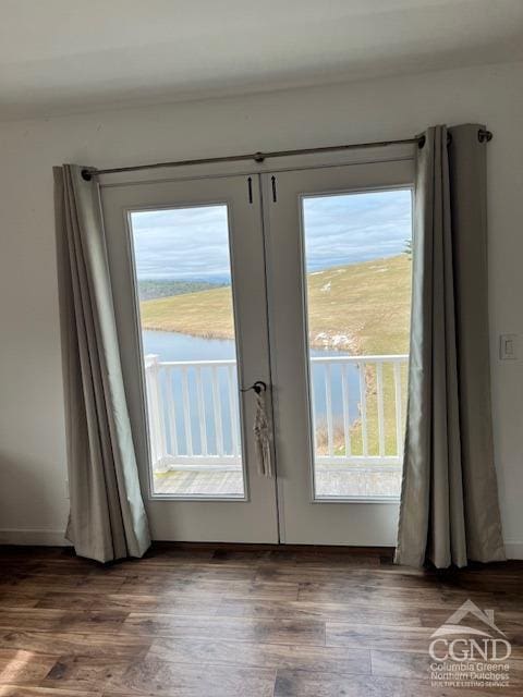 entryway with wood finished floors, a water view, and french doors