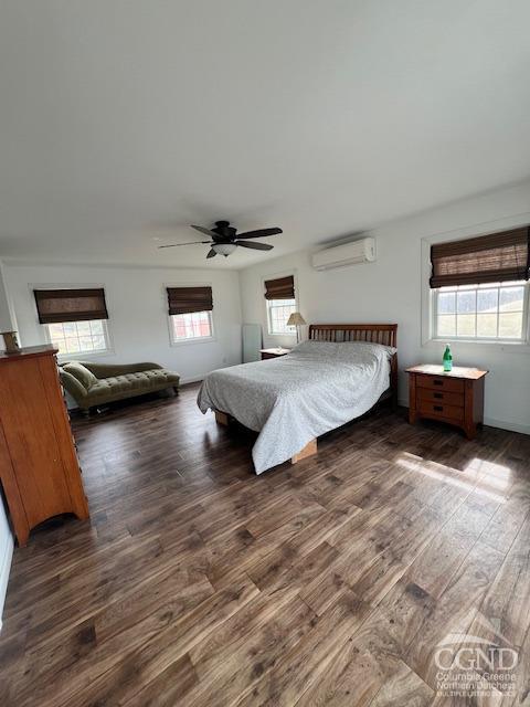 bedroom with dark wood-style flooring, a wall mounted air conditioner, and ceiling fan