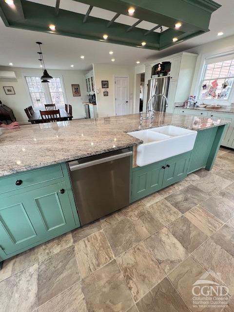 kitchen featuring plenty of natural light, stainless steel appliances, green cabinets, and a sink