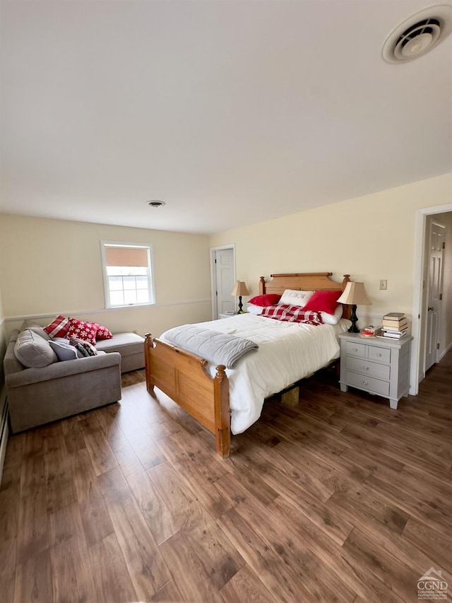 bedroom with visible vents and wood finished floors