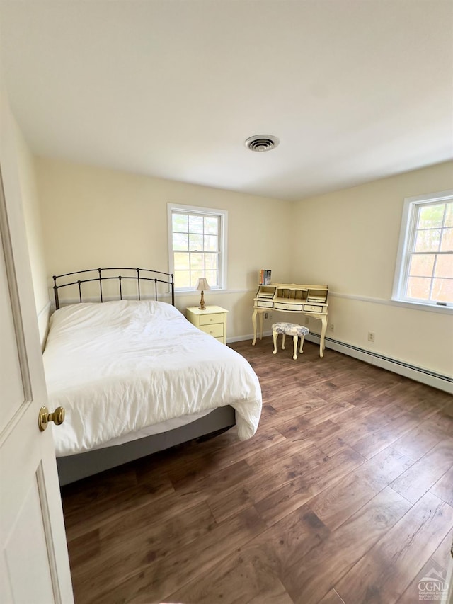 bedroom featuring visible vents, baseboards, and wood finished floors