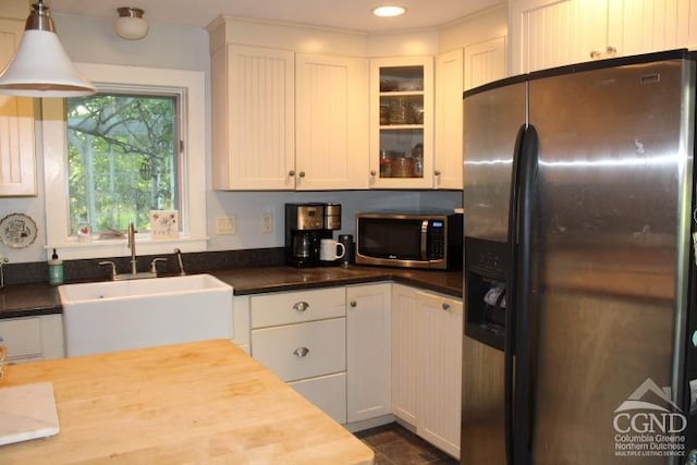 kitchen featuring white cabinets, decorative light fixtures, and stainless steel appliances