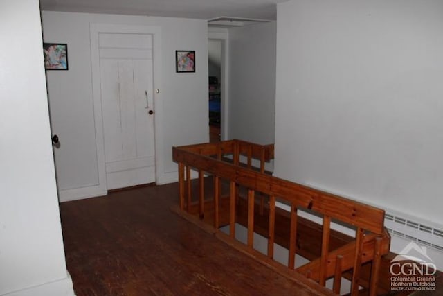 corridor featuring dark hardwood / wood-style flooring and baseboard heating