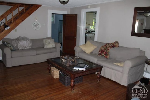 living room featuring dark hardwood / wood-style floors, ceiling fan, and ornamental molding