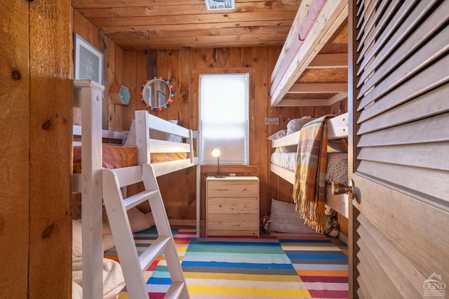 bedroom with wooden walls and wood ceiling