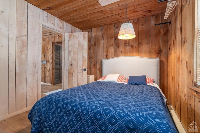 bedroom featuring wood walls, baseboards, wood finished floors, and wood ceiling