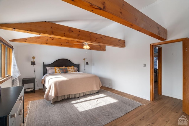bedroom with baseboards, beam ceiling, and wood finished floors