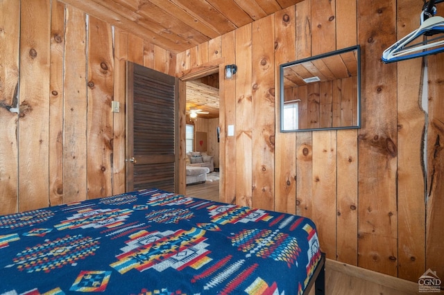 bedroom with wooden ceiling and wood walls