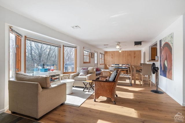 living room with visible vents, ceiling fan, and wood finished floors