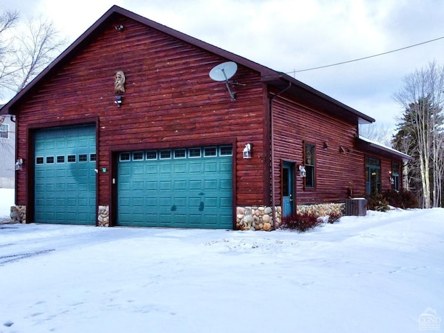 snow covered property with central AC