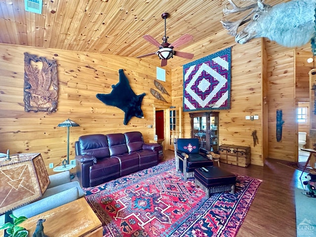 living room featuring ceiling fan, vaulted ceiling, wood walls, wood-type flooring, and wooden ceiling