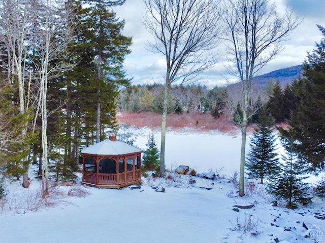 yard covered in snow featuring a gazebo and a mountain view