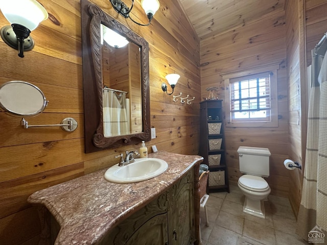 bathroom with toilet, vanity, wood walls, and lofted ceiling