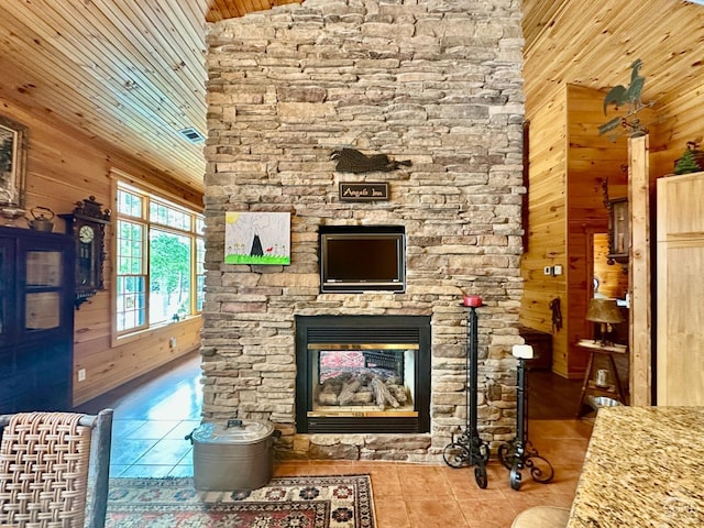 unfurnished living room with tile patterned floors, a fireplace, wood walls, and high vaulted ceiling