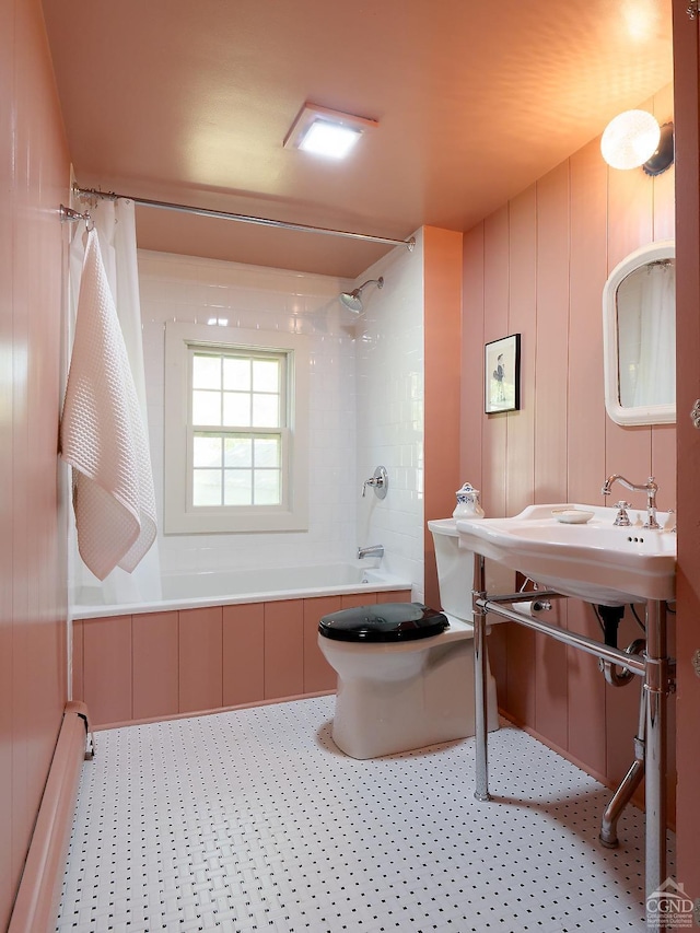 bathroom featuring toilet, shower / bathtub combination with curtain, and a baseboard heating unit