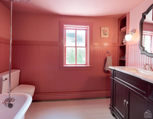 bathroom featuring vanity, baseboard heating, a bath, built in features, and toilet