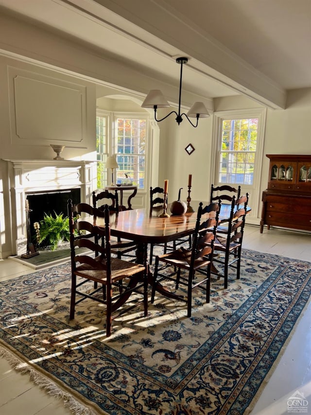 dining area featuring a chandelier and beam ceiling