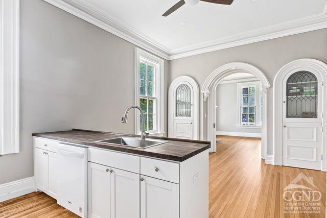 kitchen featuring white cabinets, white dishwasher, a wealth of natural light, and sink