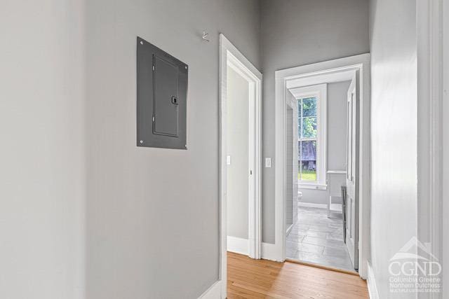 hall with light wood-type flooring and electric panel