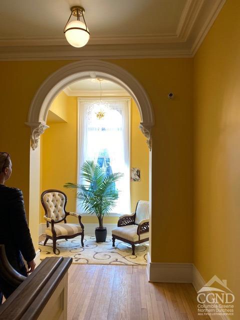 sitting room featuring crown molding and light wood-type flooring