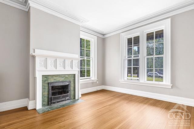 unfurnished living room with hardwood / wood-style flooring and ornamental molding