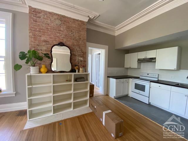 kitchen featuring white range with electric stovetop, crown molding, dark hardwood / wood-style flooring, and white cabinets