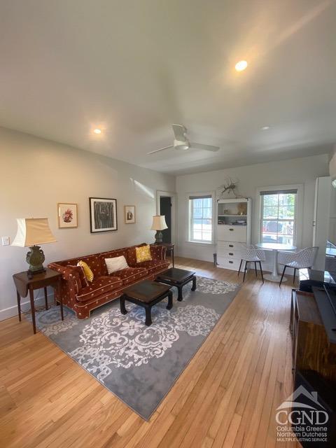 living room featuring ceiling fan, a healthy amount of sunlight, and hardwood / wood-style flooring